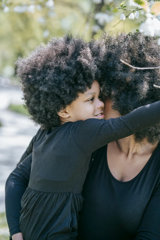 a woman holding a child in her arms, pexels contest winner, natural hair, curving black, black main color, kids