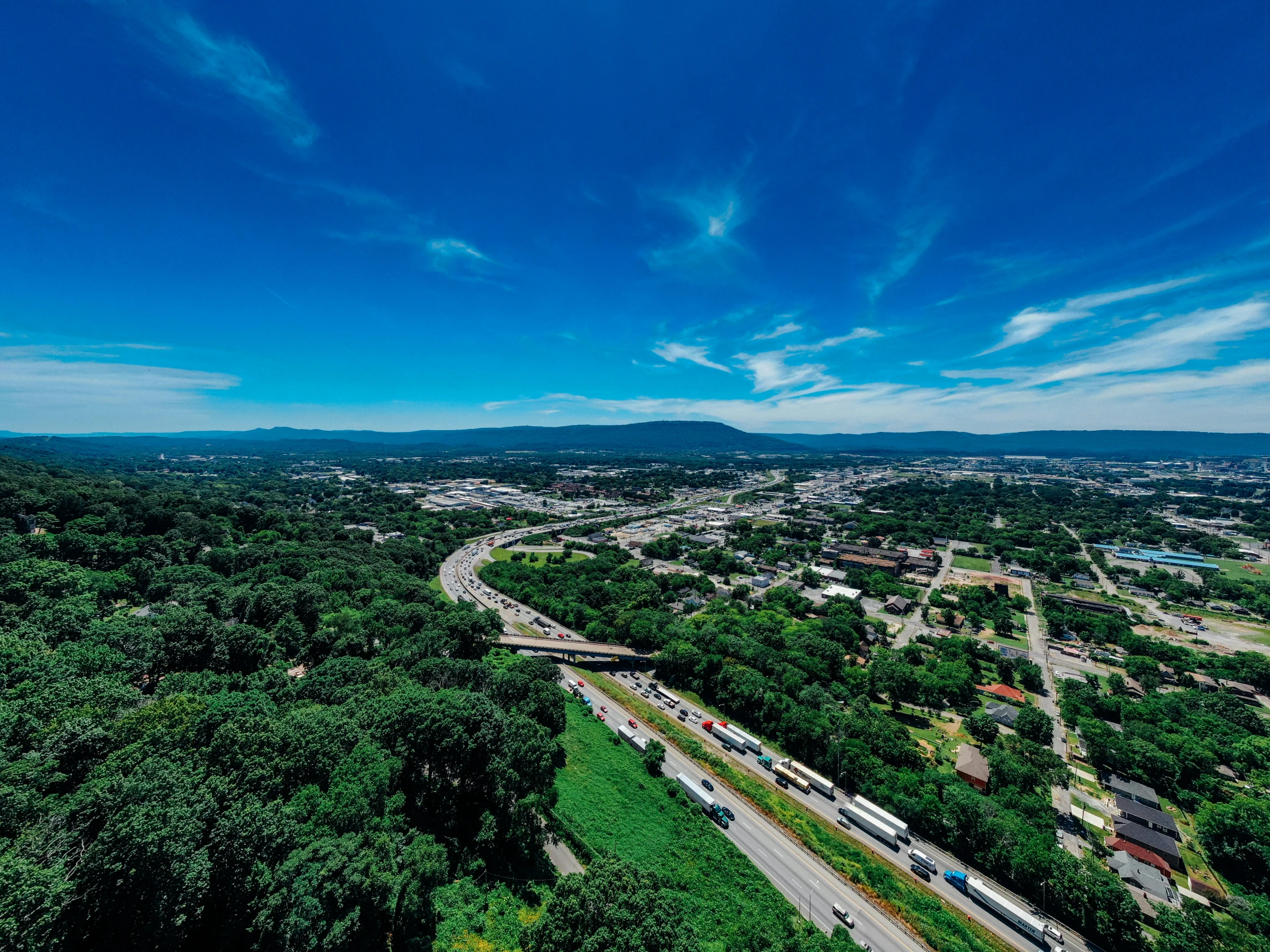 a view of a city from the top of a hill, by Joseph Severn, unsplash, blue and clear sky, high bridges, upon a peak in darien, 4k drone photography