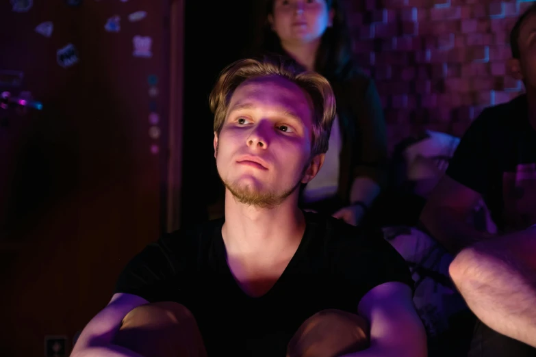 a couple of men sitting next to each other, trending on pexels, realism, violet lighting, jerma in a liminal space, serious focussed look, young adult male