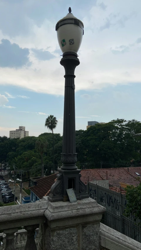 a lamp post with a clock on top of it, a statue, by Alejandro Obregón, as seen from the canopy, panorama, chimney, photo taken in 2018