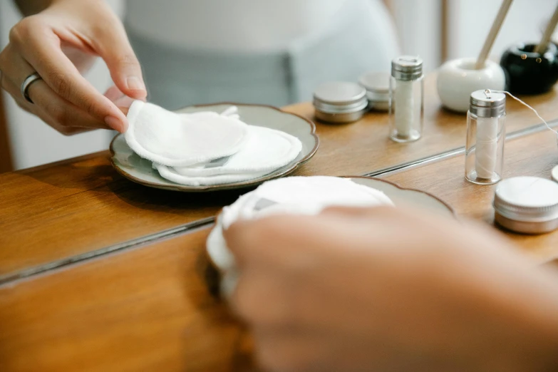 a person sitting at a table with a plate and napkin, skincare, grey, thumbnail, customers