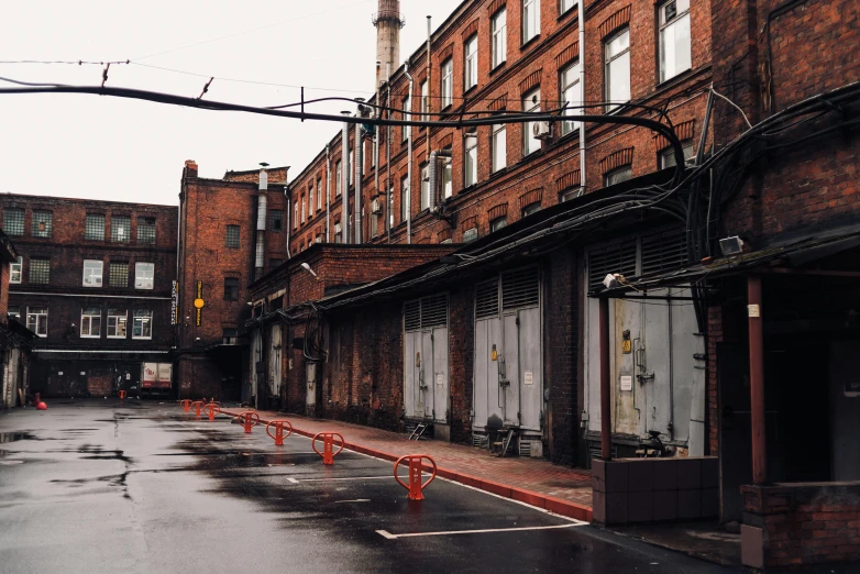 a wet street with a clock tower in the background, unsplash, graffiti, soviet yard, warehouses, 90's photo, quiet street