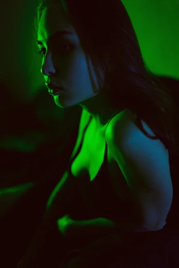 a woman sitting in front of a laptop computer, a picture, inspired by Elsa Bleda, trending on cgsociety, art photography, very dark with green lights, a young asian woman, 🤤 girl portrait, “ sensual