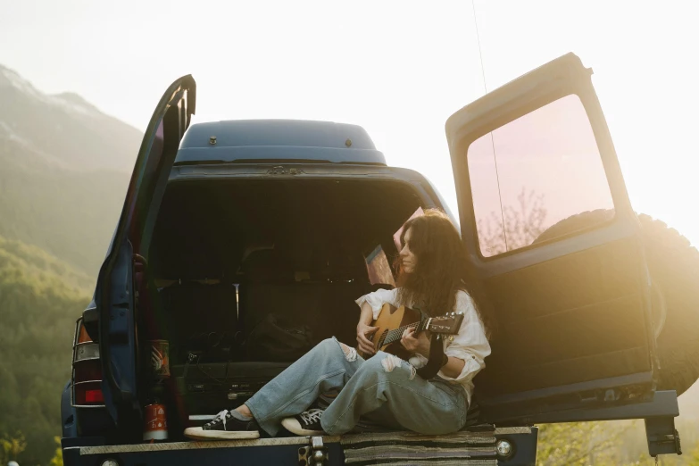 a couple of people that are sitting in the back of a truck, an album cover, pexels contest winner, women playing guitar, full body image, sunfaded, unsplash contest winning photo