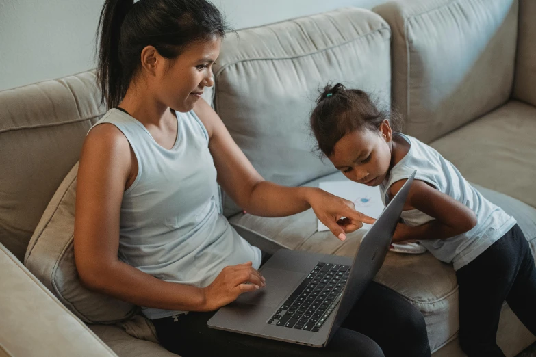 a woman and a child sitting on a couch with a laptop, pexels contest winner, programming, nivanh chanthara, avatar image, bottom angle