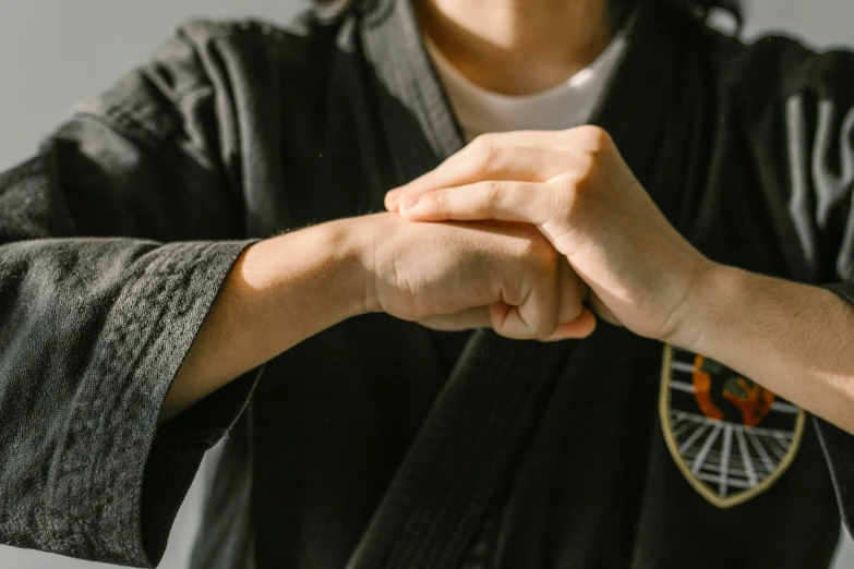 a close up of a person holding a black belt, a picture, unsplash, sōsaku hanga, partially cupping her hands, fighting pose, background image, holding each other hands