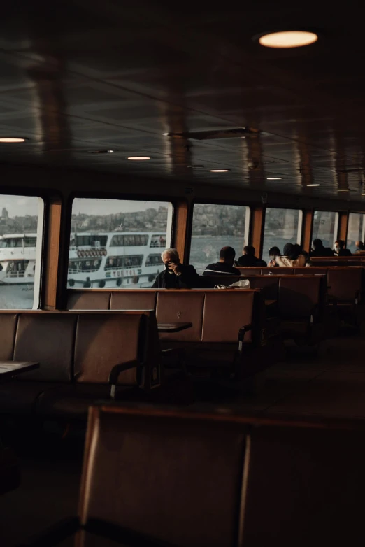 a couple of people sitting next to each other on a boat, light coming from the windows, seattle, ship interior, trending on vsco