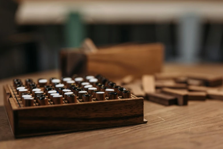 an old typewriter sitting on top of a wooden table, a jigsaw puzzle, inspired by Ceferí Olivé, unsplash, kinetic art, vials, walnut wood, in rows, smoky laboratory