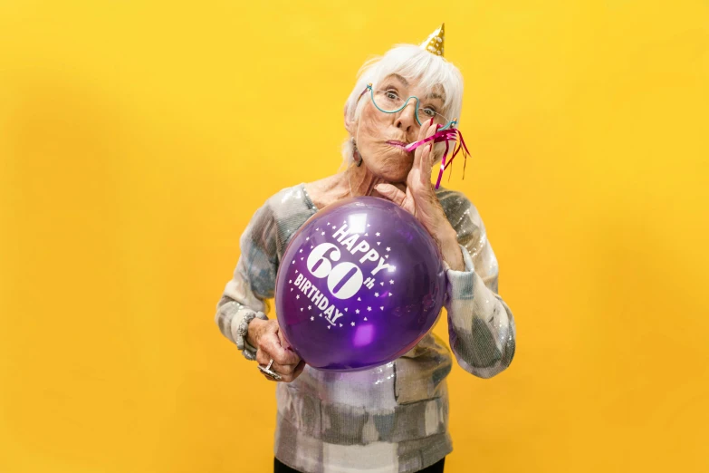 a woman holding a purple balloon in front of her face, a cartoon, by Joe Bowler, pexels contest winner, yellowed with age, celebrating a birthday, 60mm, silver and yellow color scheme