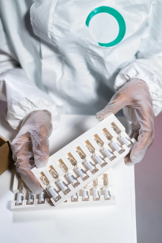 a close up of a person holding a box of pills, by Jason Felix, plasticien, pathology sample test tubes, white and teal garment, plating, white gloves