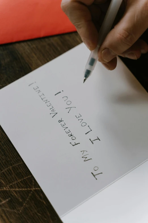 a person writing on a piece of paper with a pen, pexels contest winner, letterism, i love you, greeting card, thumbnail, cinematic full shot