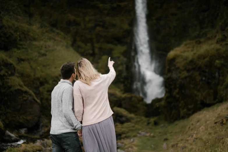 a man and woman standing in front of a waterfall, by Hallsteinn Sigurðsson, pexels contest winner, hurufiyya, looking from behind, plan, cutest, thumbnail