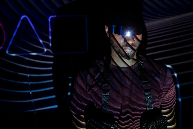 a close up of a person holding a cell phone, a hologram, by Adam Marczyński, wearing shiny black goggles, in a cyberpunk themed room, man in dark blue full body suit, aura jared and wires