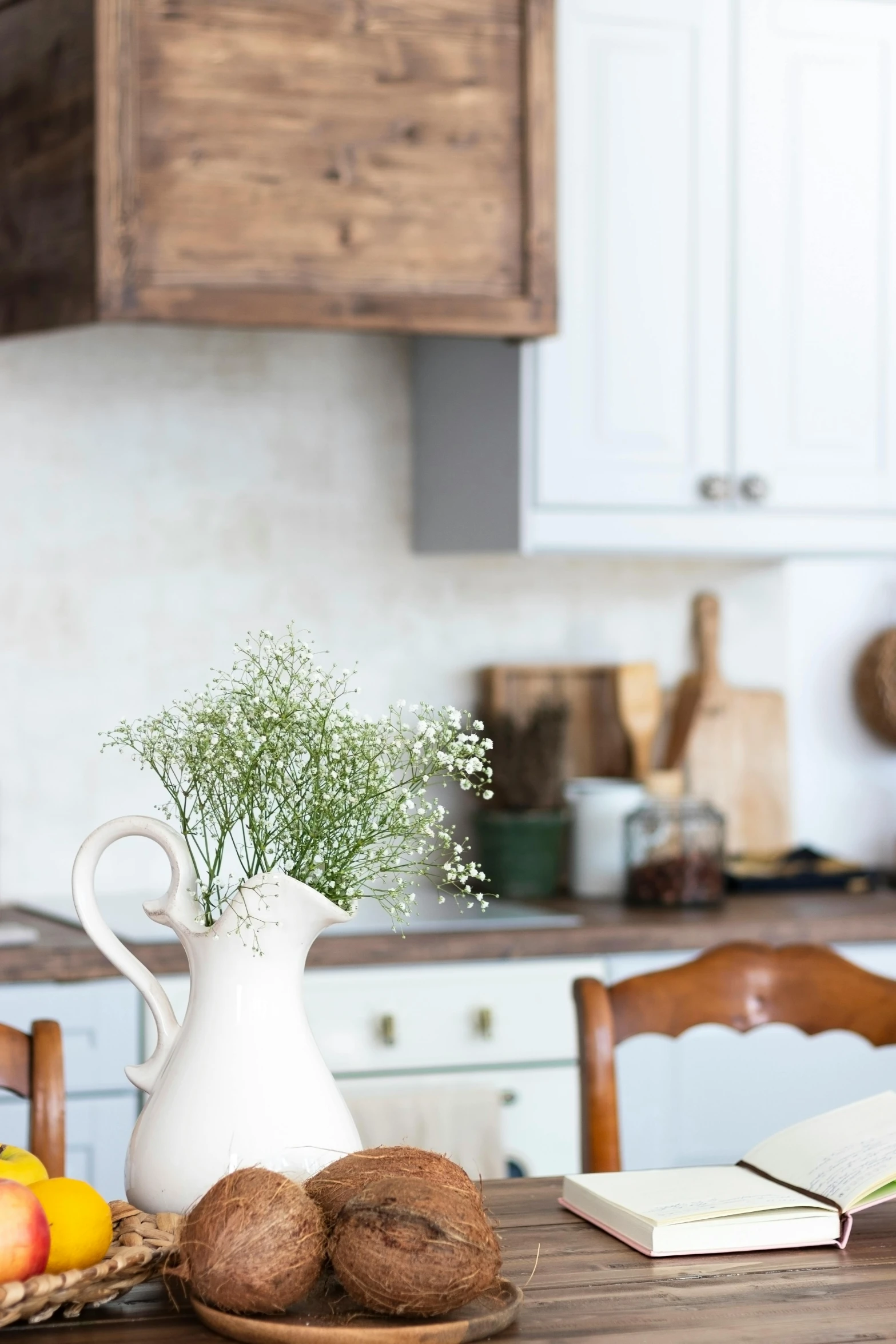 an open book sitting on top of a wooden table, inspired by William Home Lizars, featured on pinterest, white kitchen table, gypsophila, old kitchen backdrop angled view, bright sky