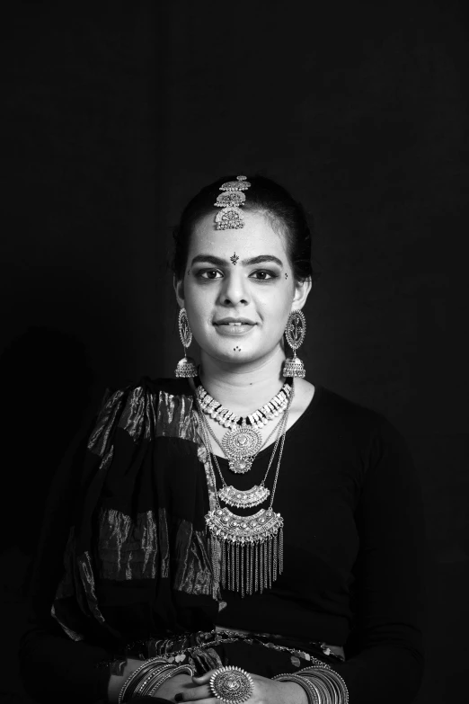 a woman in a black and white photo, inspired by T. K. Padmini, hurufiyya, huge earrings and queer make up, studio lit, instagram photo, bone jewellery