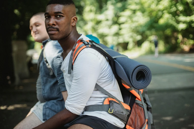 two men sitting next to each other on a bench, trending on pexels, a man wearing a backpack, grey orange, wearing a vest top, avatar image