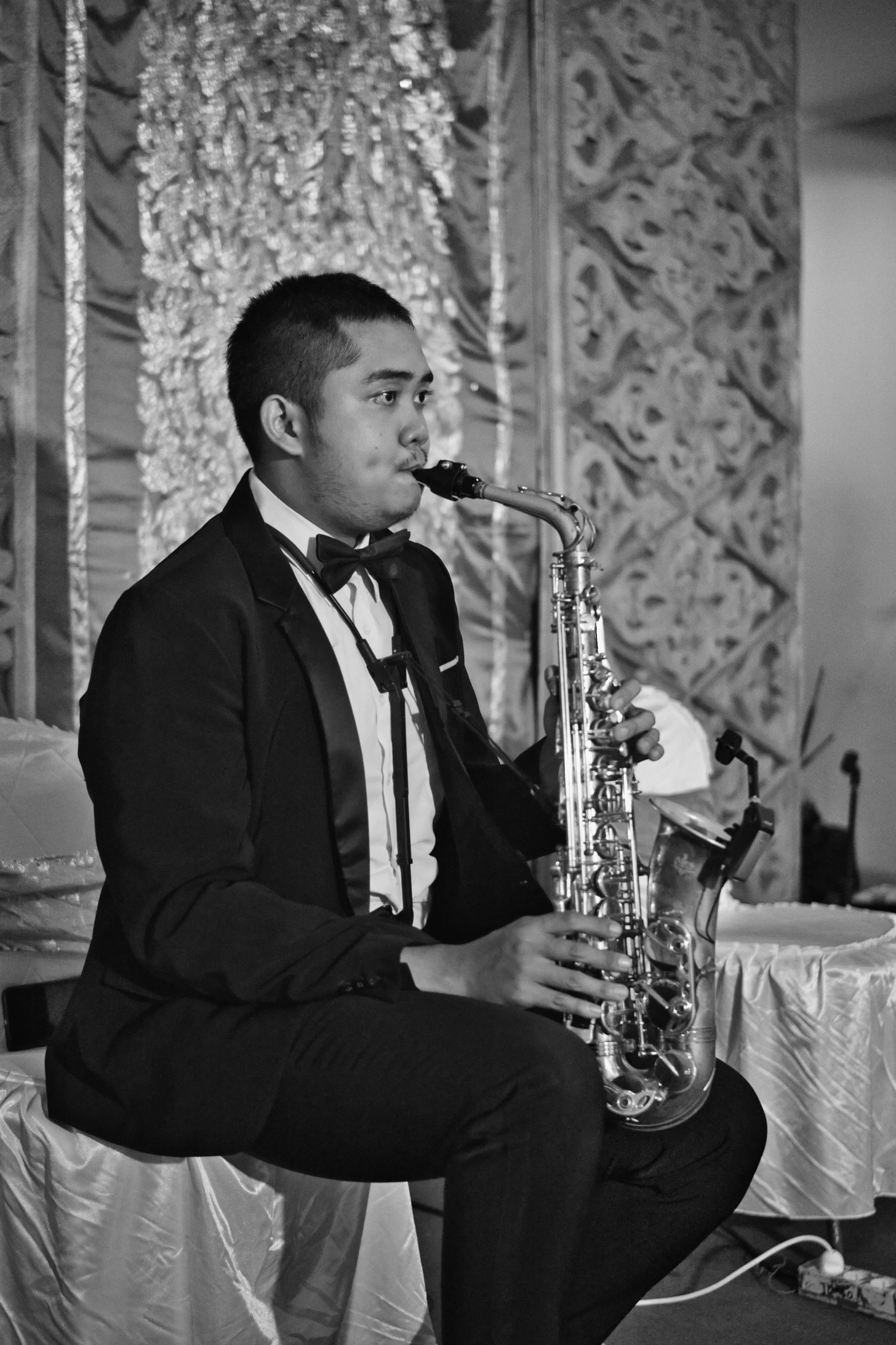 a man in a tuxedo playing a saxophone, by Basuki Abdullah, he is about 2 0 years old, 15081959 21121991 01012000 4k, nostalgic, eloy band