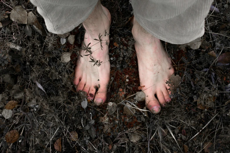 a person standing in the dirt with their bare feet, inspired by Brooke Shaden, unsplash, hyperrealism, fungal, covered in runes, pale grey skin, overgrowth