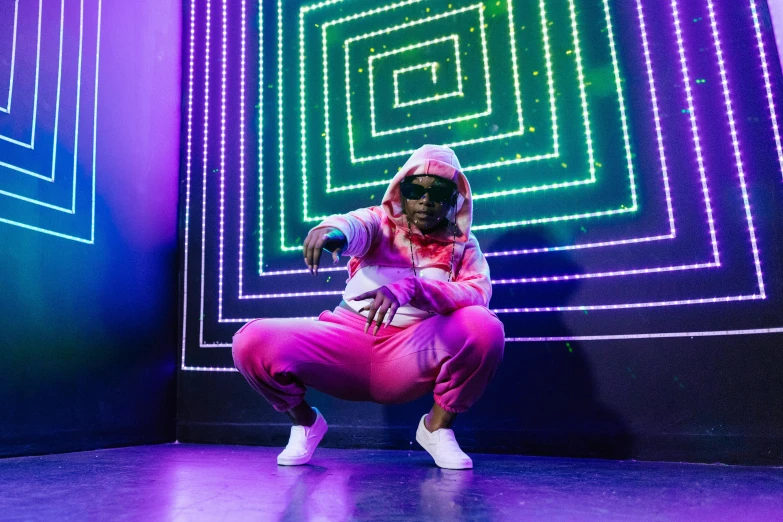 a person in a pink outfit on a stage, funk art, wearing a hoodie and sweatpants, with neon lighting, full costume, bored ape nft