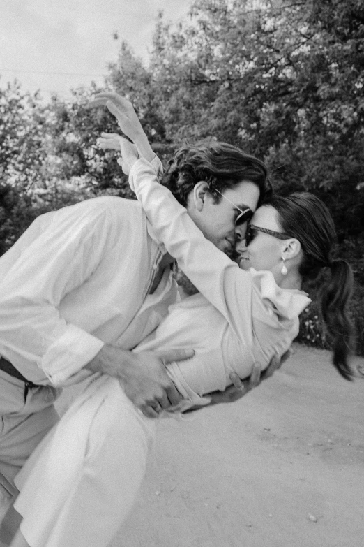 a black and white photo of a man holding a woman, a black and white photo, by Anita Malfatti, pexels, wearing white suit and glasses, love in motion, timothee chalamet, instagram picture