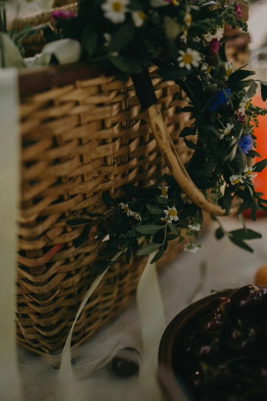 a basket of fruit sitting on top of a table, floral crown, olives, medium close shot, rituals