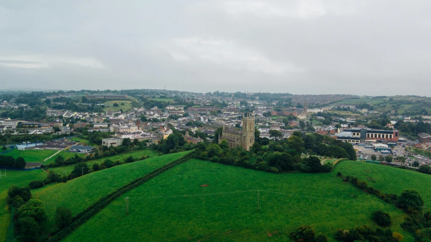 a view of a town from the top of a hill, an album cover, unsplash, madgwick, slight overcast weather, 2000s photo, 4k footage