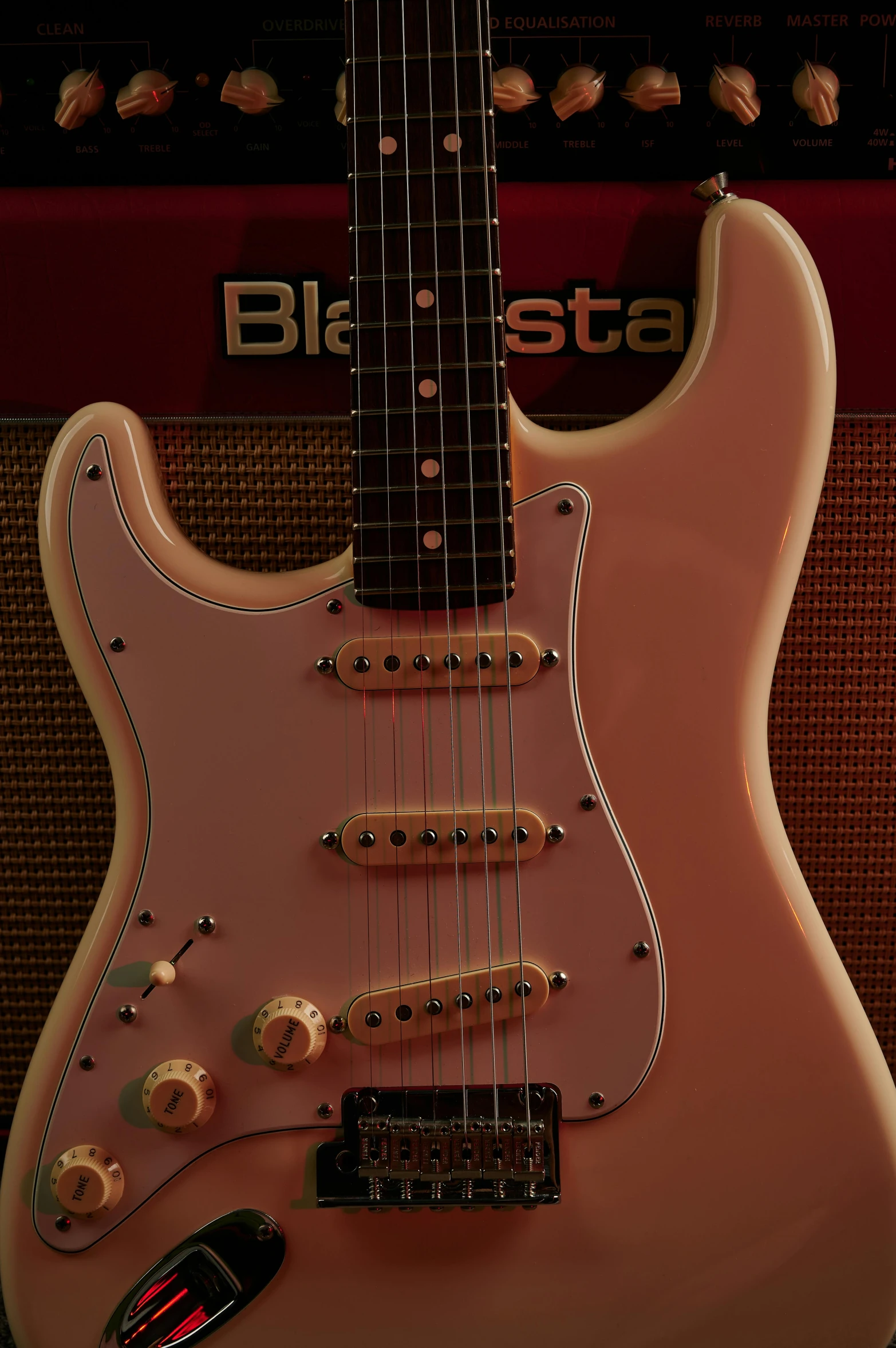 a close up of a guitar in front of a amplifier, an album cover, by Jesse Richards, pastel pink skin tone, 1958, replica model, electronic