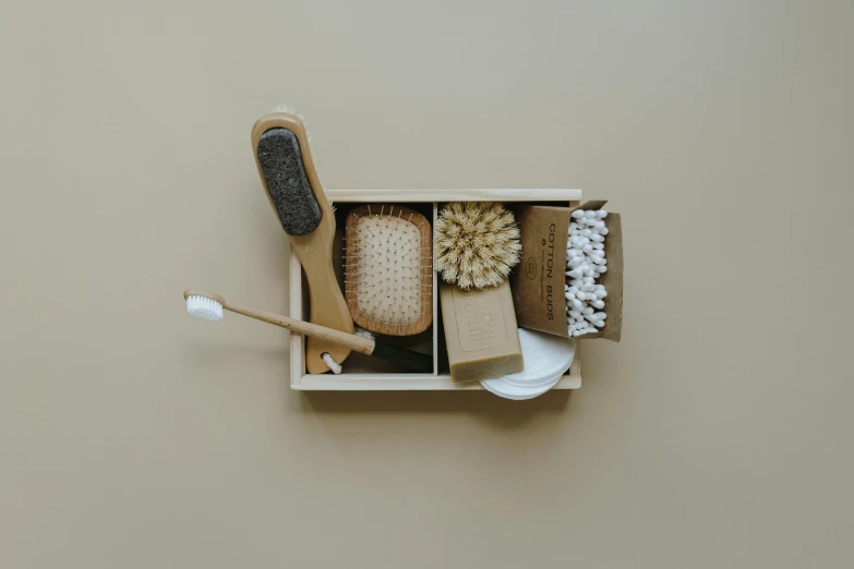 a couple of brushes sitting inside of a box, by Eden Box, minimalism, beige, bath, foot, knolling