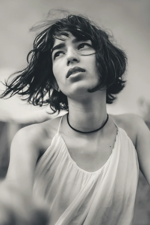 a black and white photo of a woman in a dress, a black and white photo, trending on pexels, wavy short hair, the wind moves her shirt, 🤤 girl portrait, wearing choker