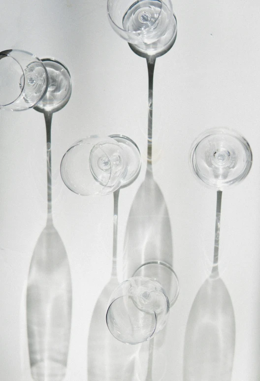 a group of wine glasses sitting on top of a table, inspired by Cerith Wyn Evans, kinetic art, ultrafine detail ”, large)}], light from bottom, escaping air bubbles