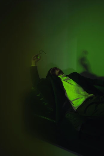 a man laying on top of a bed under a green light, an album cover, pexels, neo-figurative, drunkard, demna gvasalia, spooky lighting, cinematic outfit photo