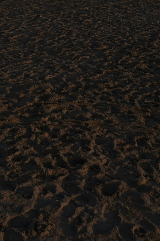 a man flying a kite on top of a sandy beach, an album cover, by Alexander Mann, reddit, 4 k seamless mud texture, made of tar, unreal engine 5 detail, (night)