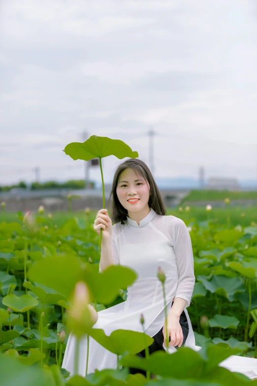 a woman sitting in a field holding a leaf, inspired by Cui Bai, 8k selfie photograph, standing on a lotus, ((portrait)), 15081959 21121991 01012000 4k