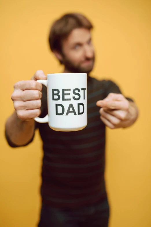 a man holding a coffee mug that says best dad, pexels, happening, studio photo, panel, ap news photo, f / 2 0