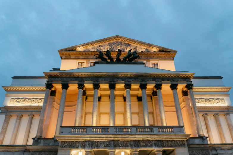 a large building with a clock on top of it, by Julia Pishtar, neoclassicism, dramatic lighting from below, war theatre, thumbnail, in the evening