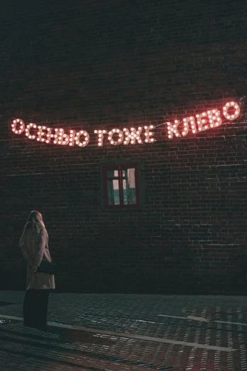 a person standing in front of a brick building, neo kyiv, neon signs in the distance, instagram picture, very poetic