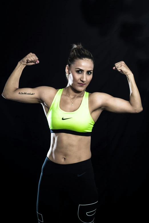 a woman flexing her muscles against a black background, a portrait, inspired by Gina Pellón, promotional image, sports, kyza saleem, in a fighting pose