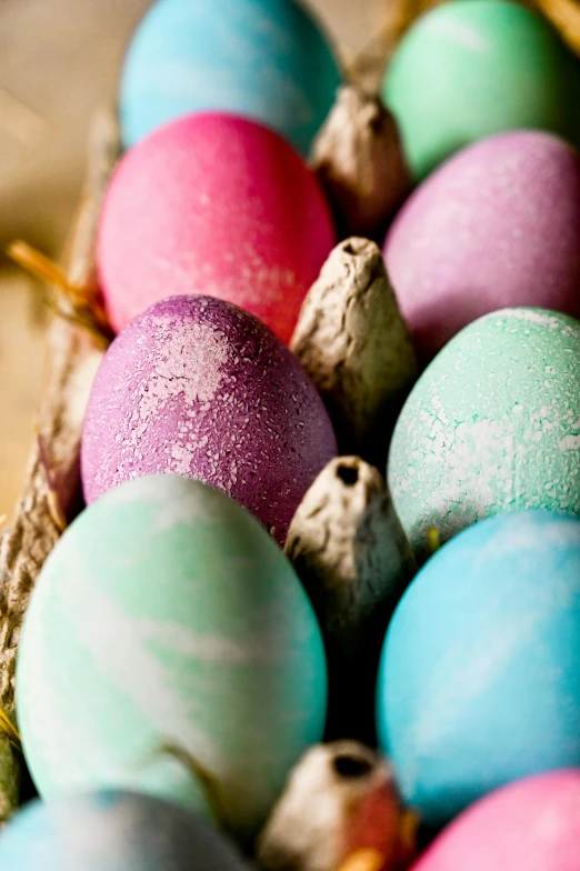 a basket full of colored eggs sitting on top of a table, pink and blue and green mist, chalked, upclose, burnt