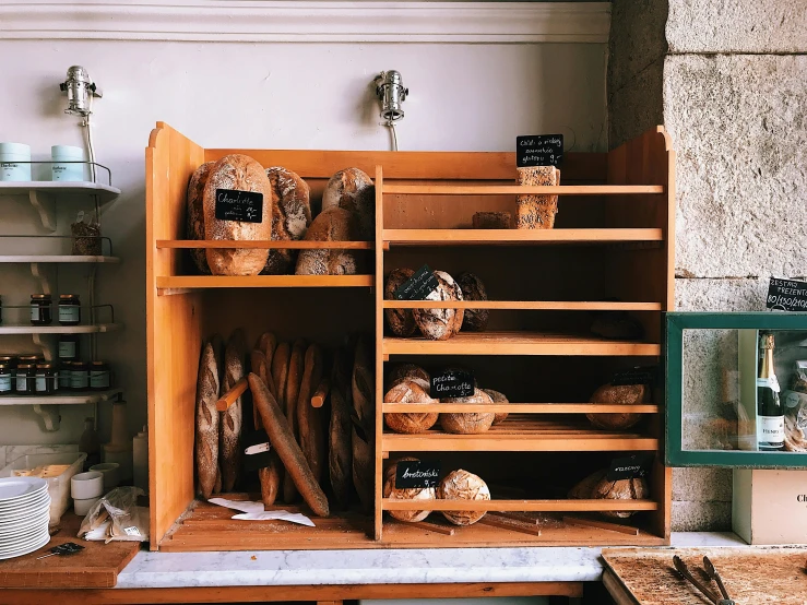 a shelf filled with lots of different types of bread, a marble sculpture, unsplash, workbench, arrendajo in avila pinewood, old experimentation cabinet, thumbnail