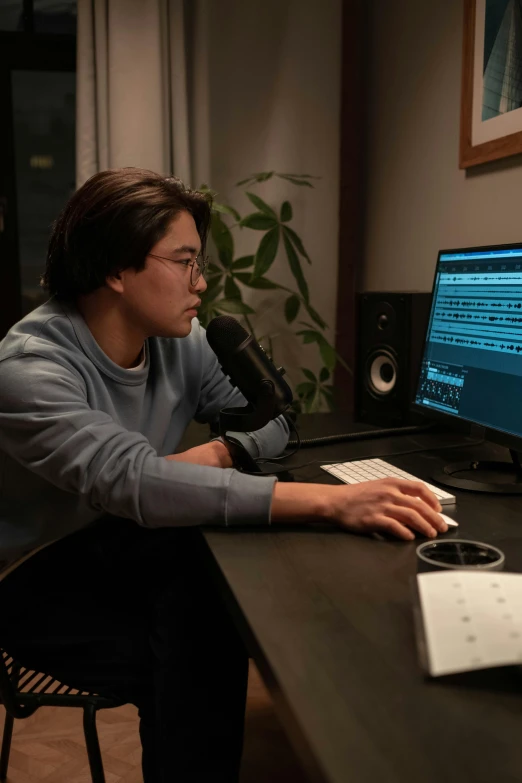 a man sitting at a desk in front of a computer, reddit, production still, howard pak, promo image, programming