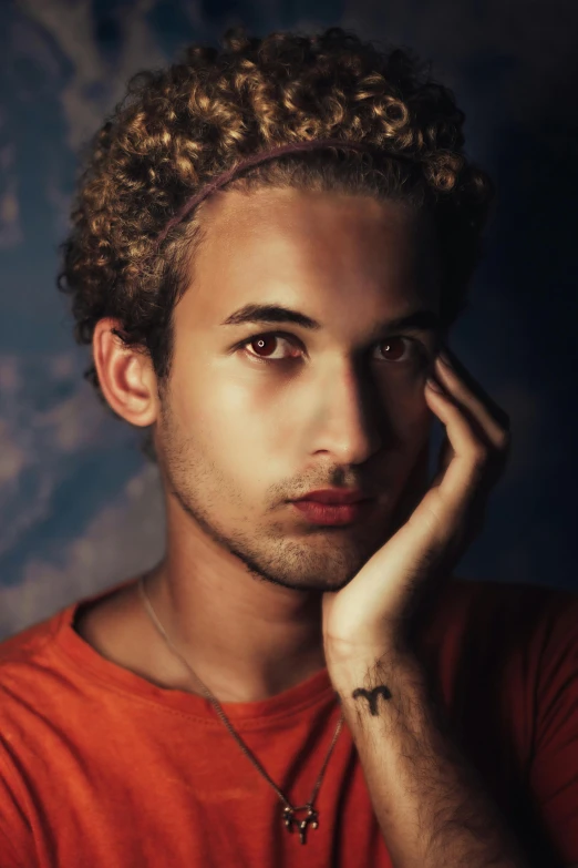 a close up of a person with a hand on his face, an album cover, inspired by Alexis Grimou, trending on pexels, antipodeans, curly and short top hair, attractive young man, thiago alcantara, innocent look. rich vivid colors
