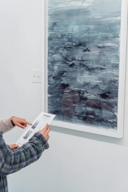 a woman reading a book in front of a painting, inspired by Gerhard Richter, interactive art, cyanotype, jeongseok lee, one person in frame, charcoal smudges