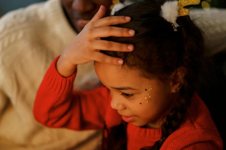 a little girl sitting in front of a christmas tree, pexels contest winner, caring fatherly wide forehead, diverse, praying, gold