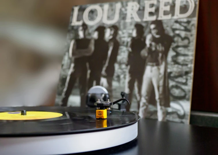 a record player sitting on top of a table, an album cover, inspired by Leila Faithfull, trending on pexels, photorealism, lucky luke, rocking out, bead and reel, low angle wide shot