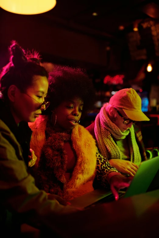 a group of people sitting at a table looking at a laptop, chinatown bar, photo of a black woman, warm coloured, performance