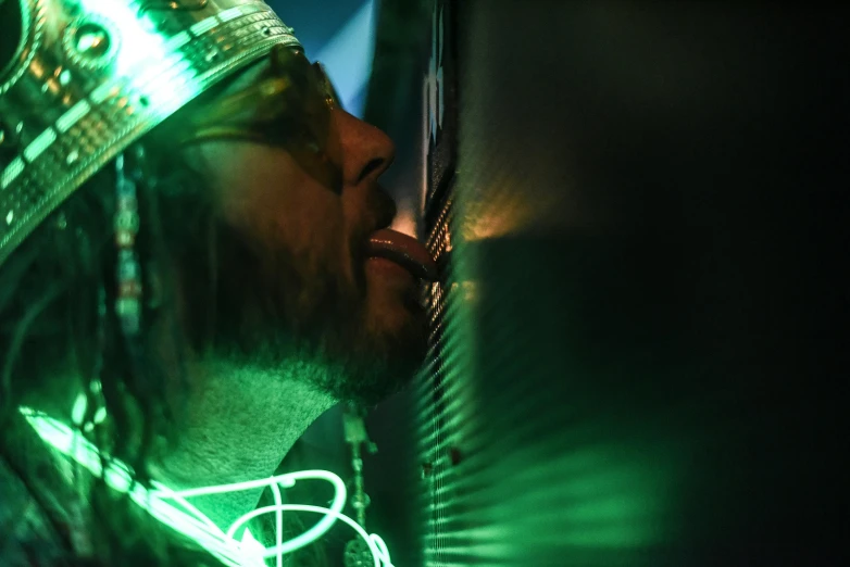 a man with a crown on top of his head, a hologram, by Matt Cavotta, unsplash, holography, kissing, green steampunk lasers, standing in a server room, the straw is in his mouth