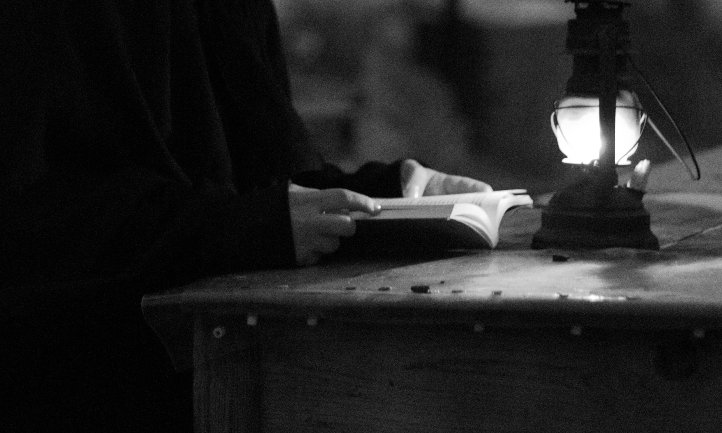 a black and white photo of a person reading a book, by Dariusz Zawadzki, nun, the candle is on a wooden table, 15081959 21121991 01012000 4k, detail