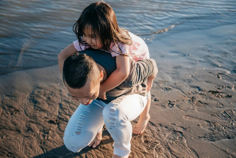 a man carrying a little girl on the beach, pexels contest winner, avatar image, asian man, hugging her knees, maintenance