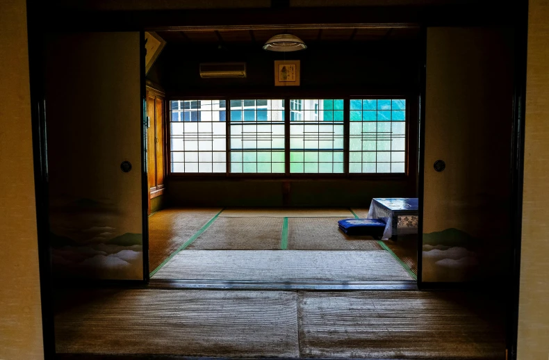 a room with an open door and a mat on the floor, a picture, inspired by Sesshū Tōyō, unsplash, shin hanga, many large green windows, colored photo, japanese high school, bathhouse