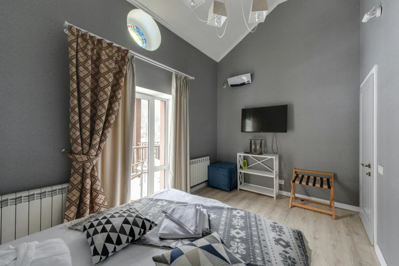 a bed room with a neatly made bed and a flat screen tv, instagram, art nouveau, soft grey and blue natural light, located in hajibektash complex, vaulted ceiling, high-quality photo
